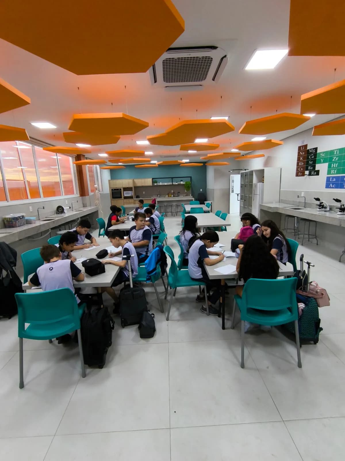 Professor guiando alunos em atividades STEAM em sala de aula